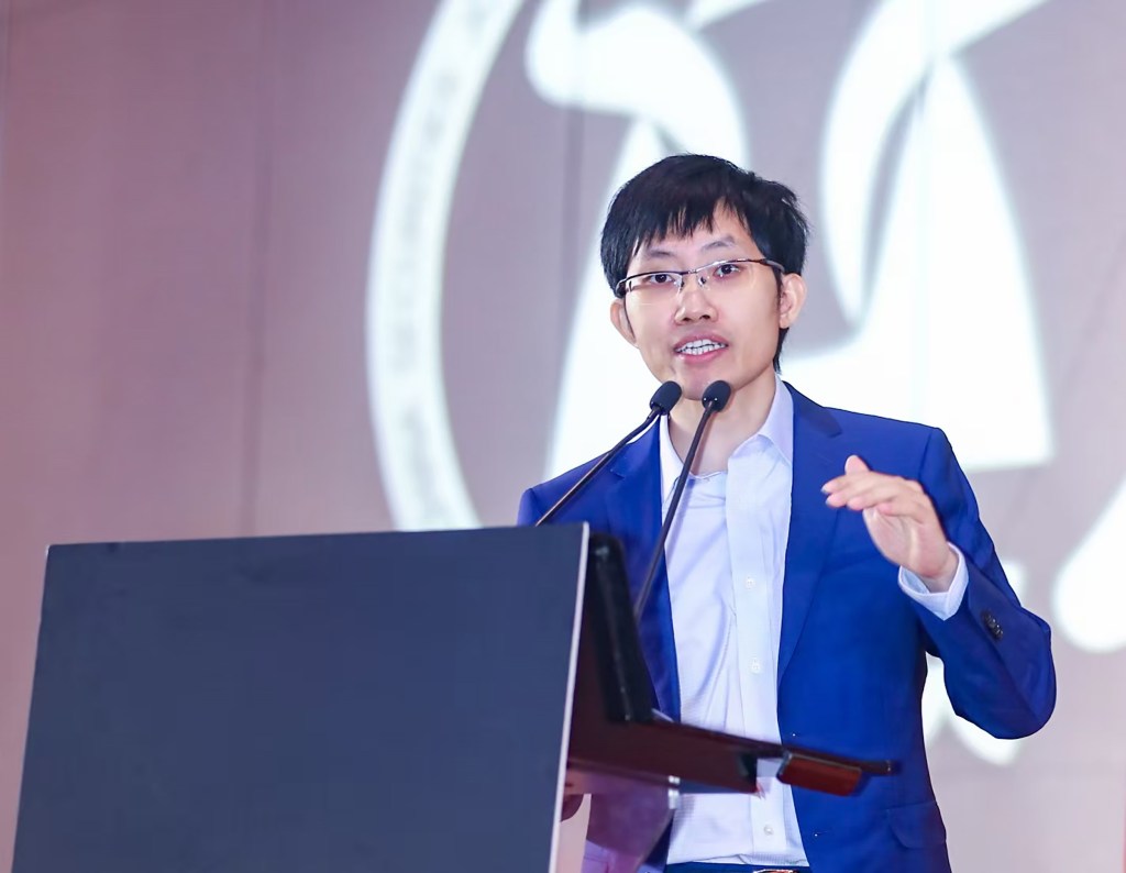 Liang Wenfeng, founder of DeepSeek, speaking at a podium.