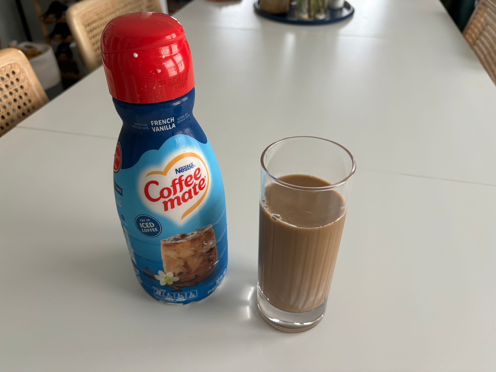 French vanilla coffeemate creamer next to glass of coffee with cream in it