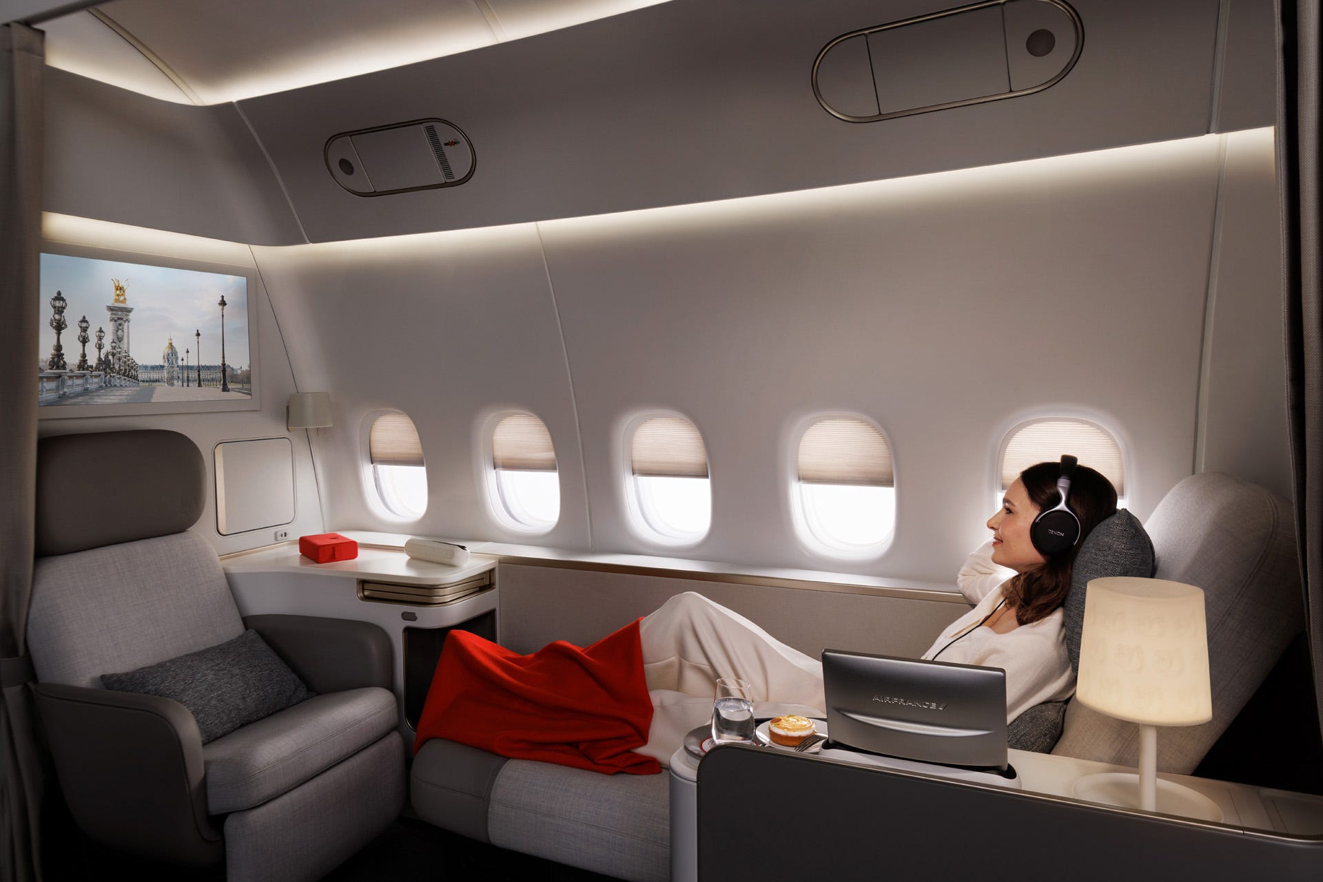 A woman reclining and watching TV in Air France's new La Première first class suite.