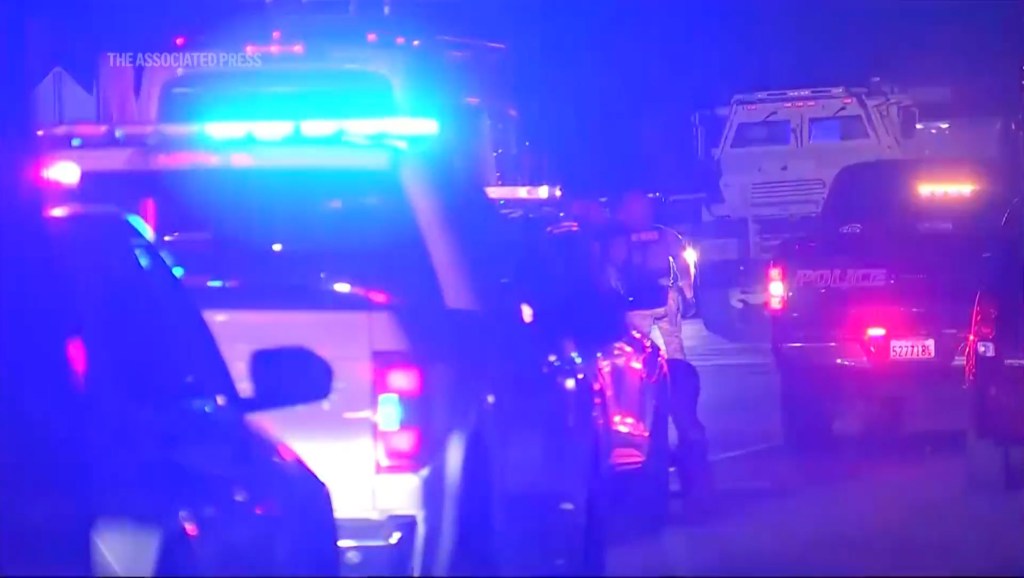 Police cars and officers at a night scene.
