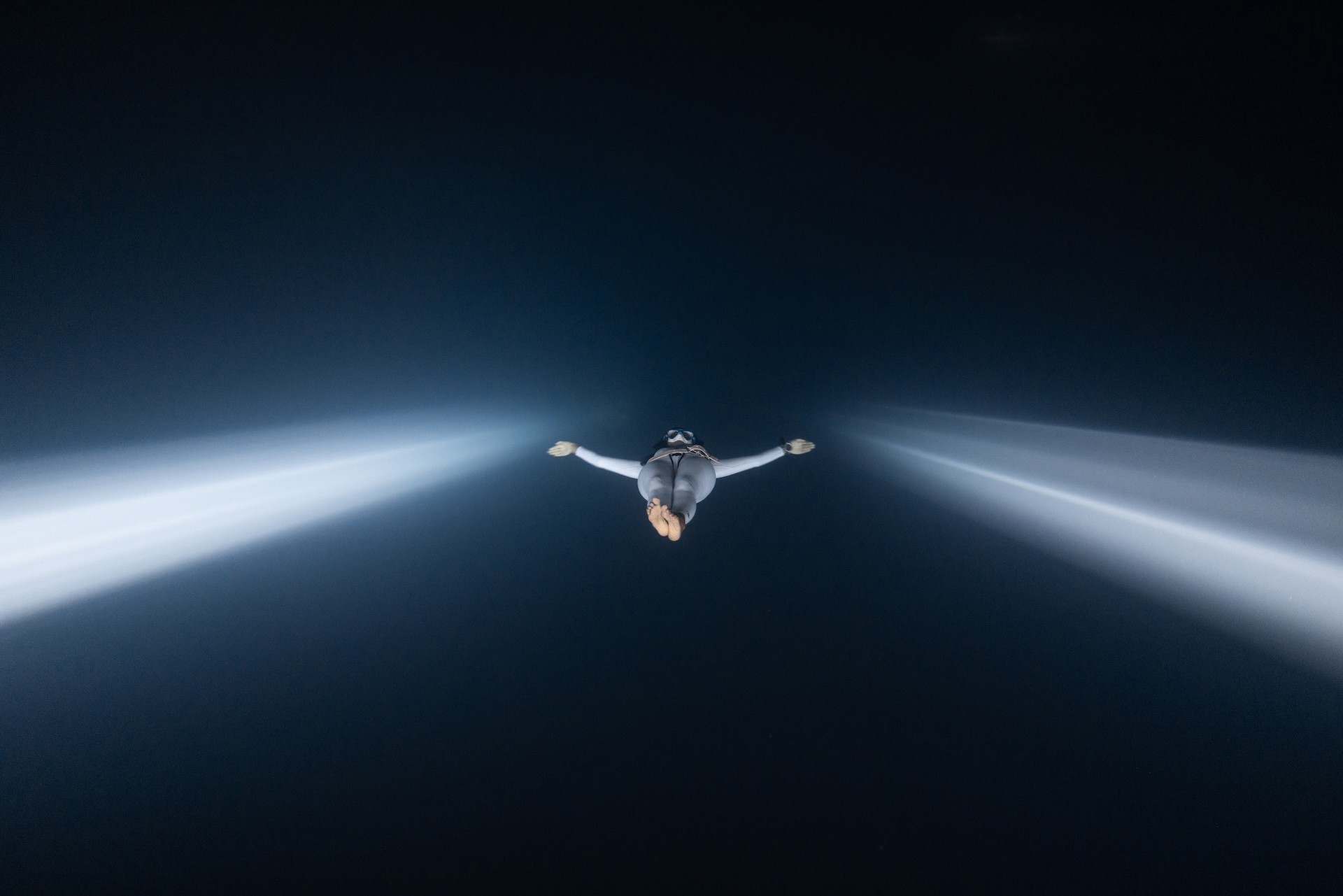 A long-exposure image of a fish swimming with fins that appear to have glowing edges.