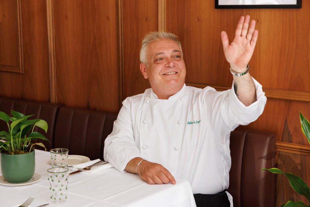 The esteemed chef waves to folks outside of his new Soho restaurant.