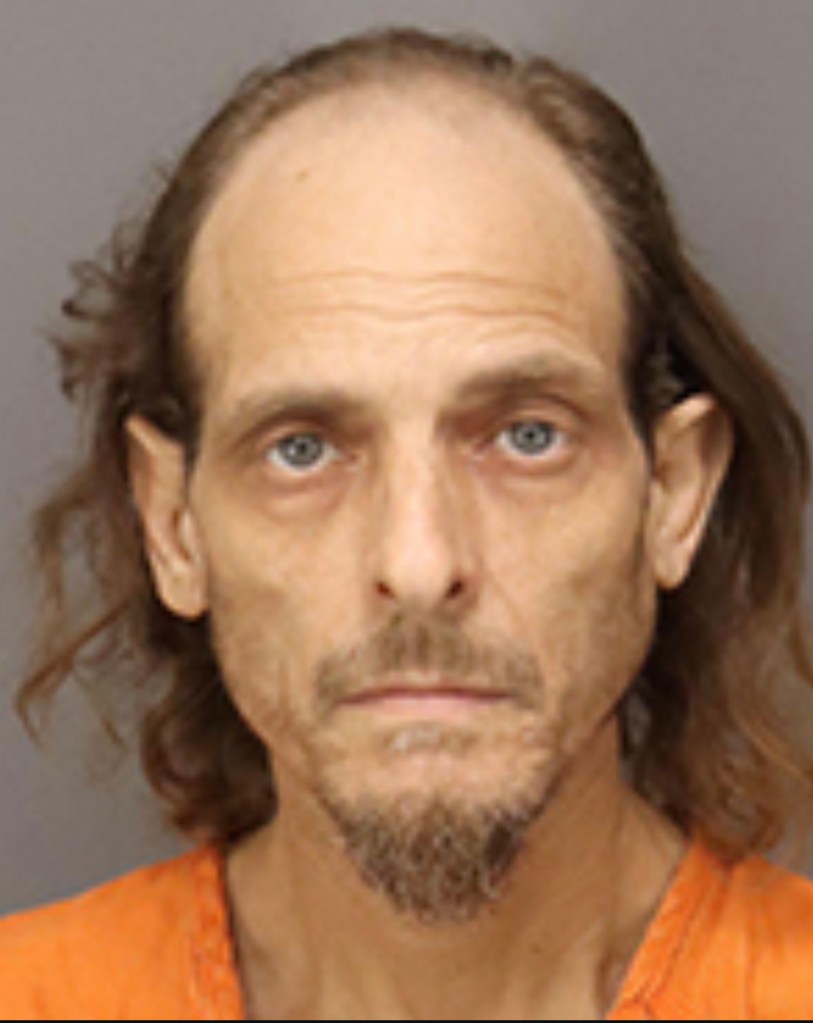 Mugshot of a man in an orange jumpsuit.