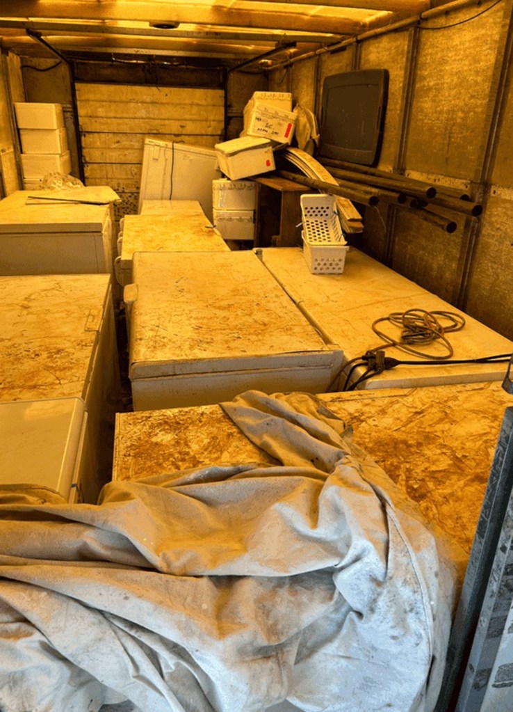 Truck filled with freezers and other items.