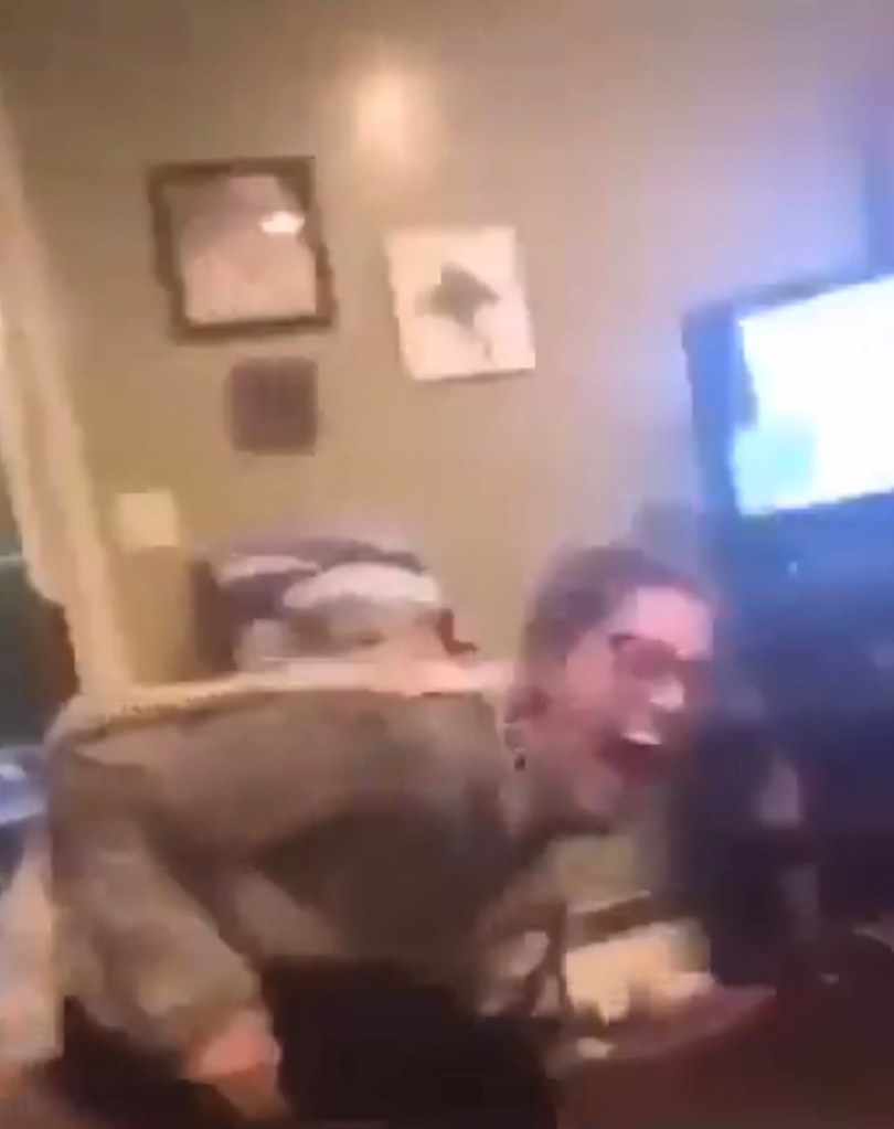 Two women laughing in a living room.