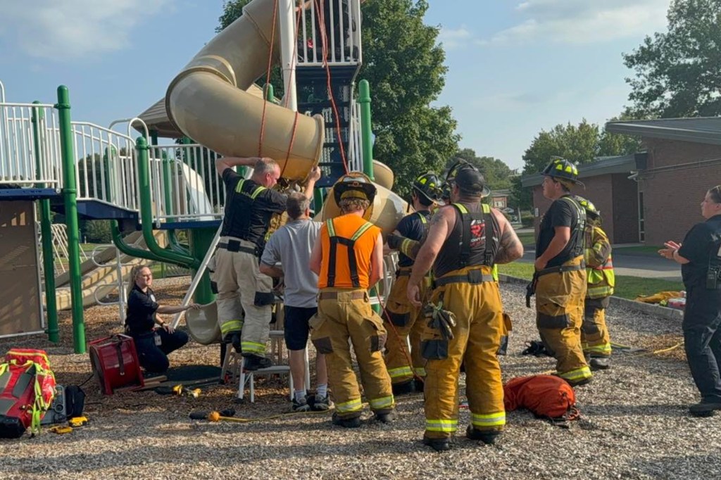 Firefighters removing a playground slide.