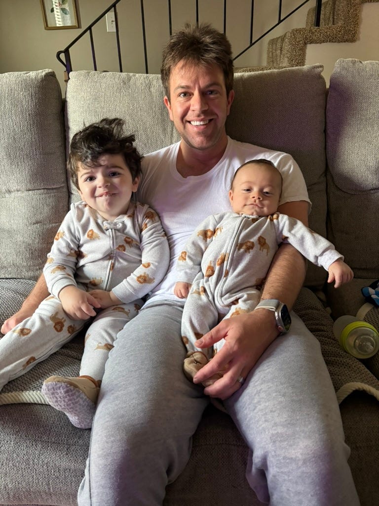 Dad holding two sons on couch
