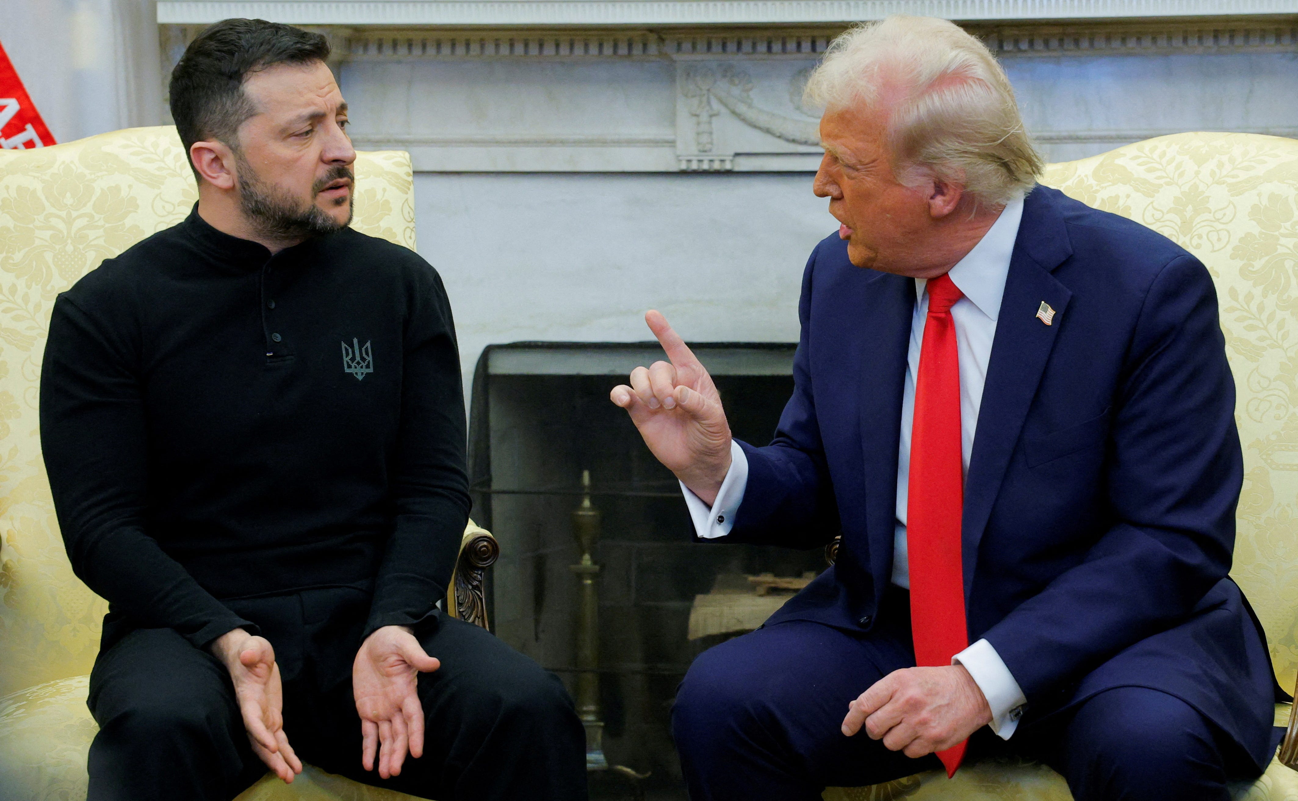 US President Donald Trump pointing his finger at Ukrainian President Volodymyr Zelenskyy while the pair sit on armchairs and talk.