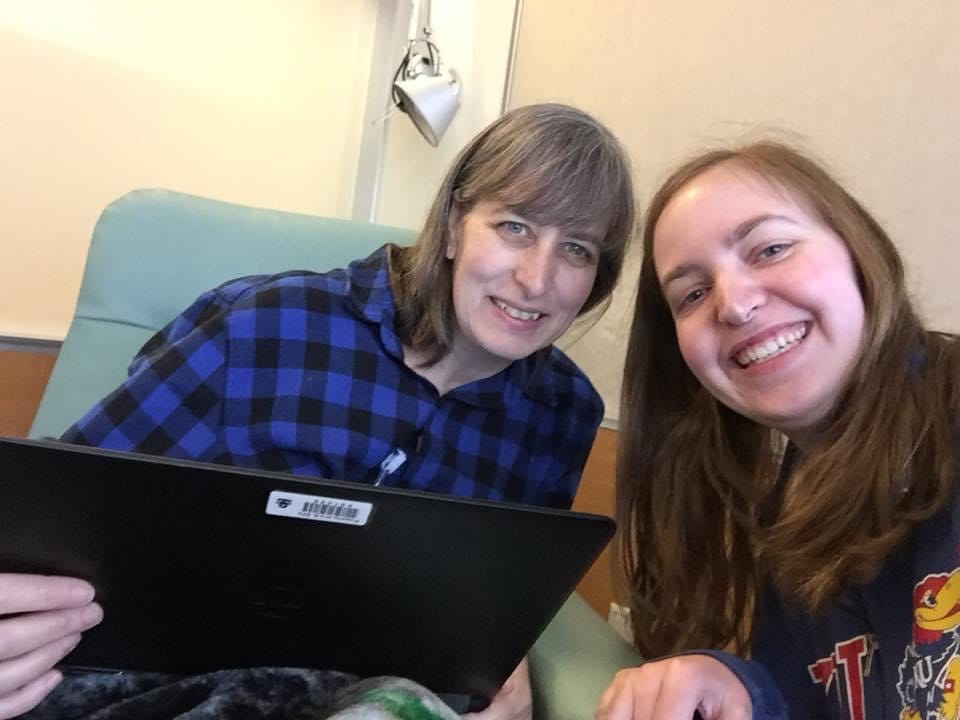 Woman in chair getting chemo smiling with daughter