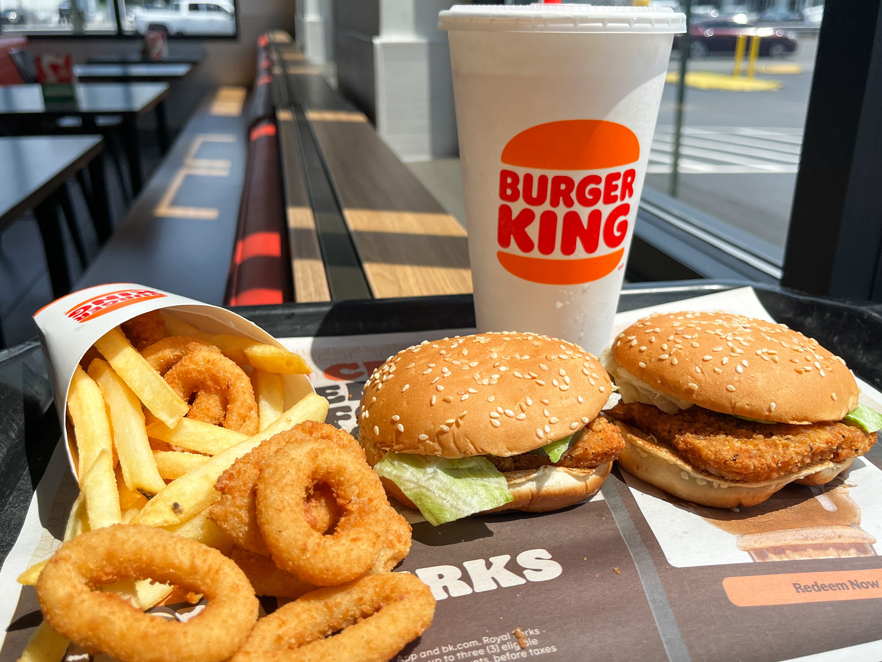 Fries, onion rings, two fried-chicken sandwiches, and a drink on a tray at Burger King.