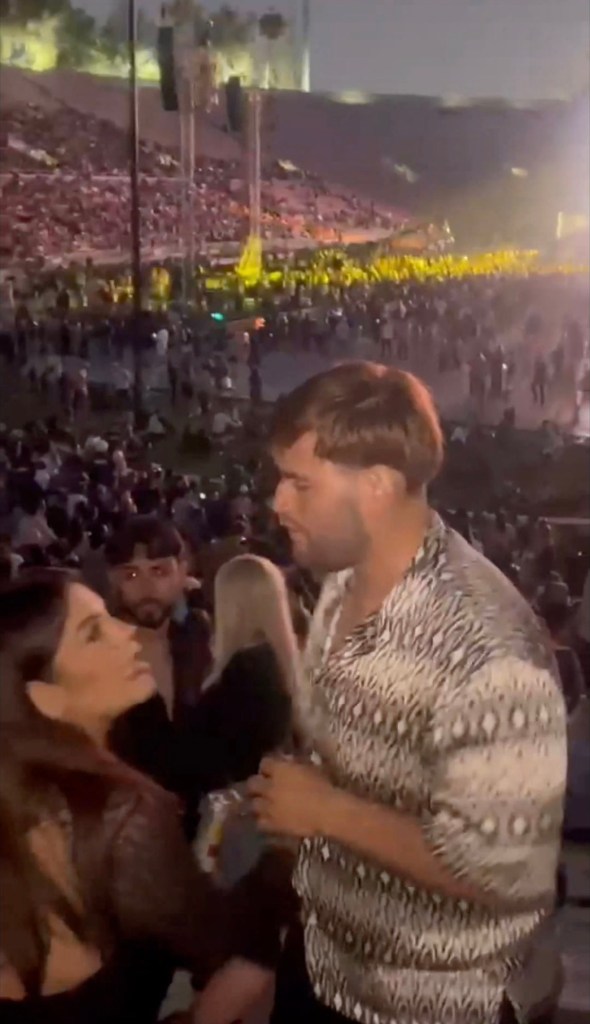 Video still of a man assaulting a woman at a concert.