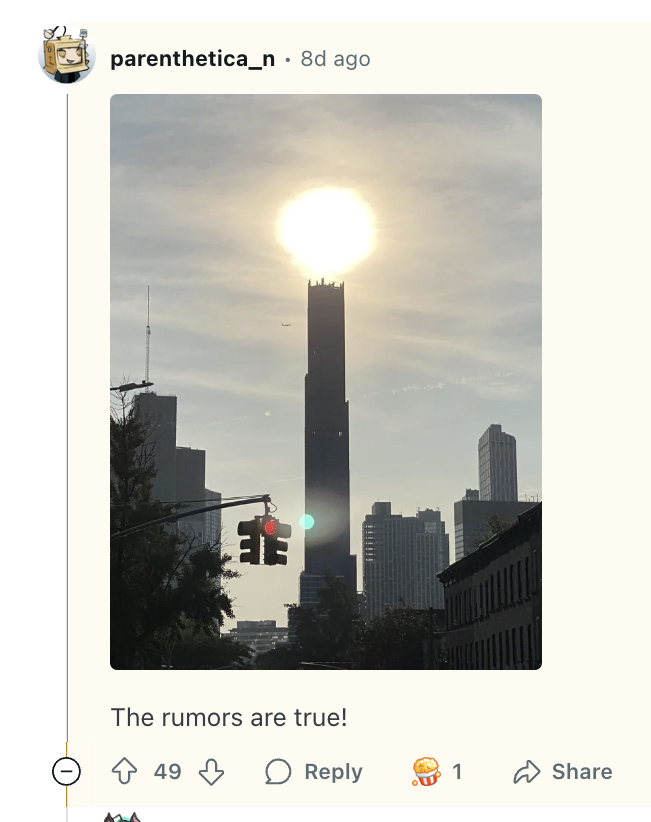 Photo of a tall building silhouetted against a bright sun, with other buildings and a traffic light in the foreground.