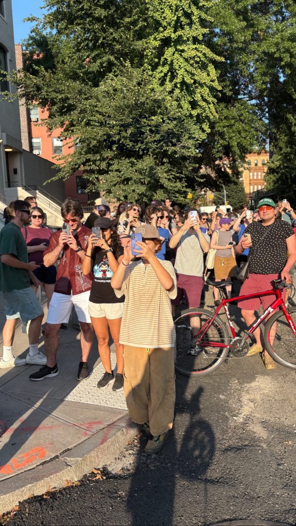 Crowd of people taking photos with their phones.