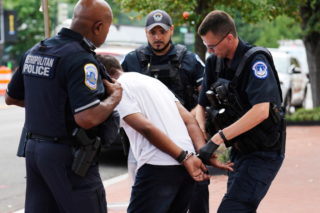 Capitol Police officer, right, with the help of Washington Metropolitan police officers, take a man into custody near Union Station, Friday, Aug. 15, 2025, in Washington.