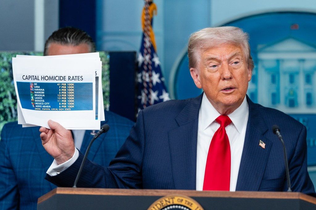 President Donald Trump holds up a statical graph on DC homicide rates as he speaks during a news conference on crime in the nation's capital at the James S. Brady Press Briefing Room at the White House in Washington, D.C. on Monday, Aug. 11, 2025. 