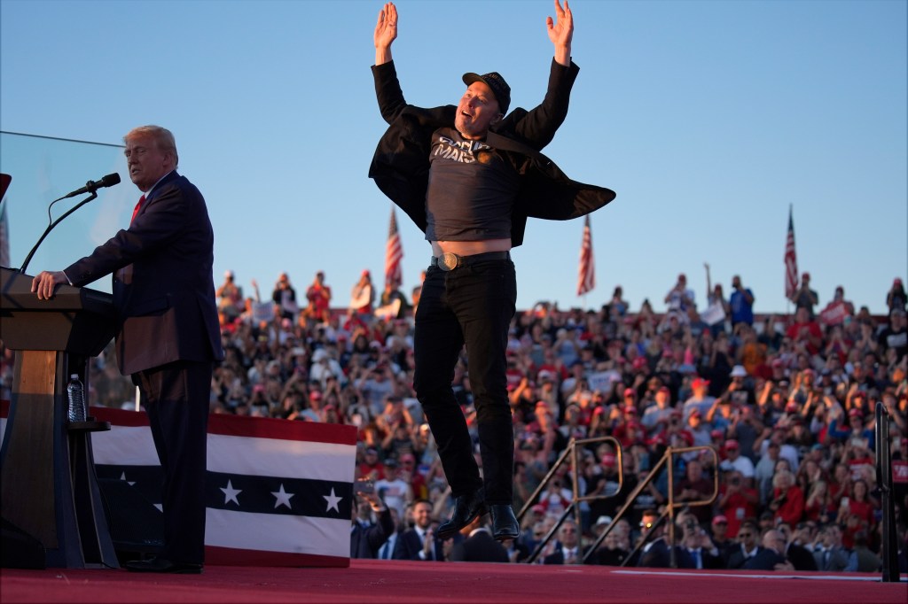 Musk jumps on the stage as Republican presidential nominee former President Donald Trump speaks at a campaign rally at the Butler Farm Show, Oct. 5, 2024, in Butler, Pa.