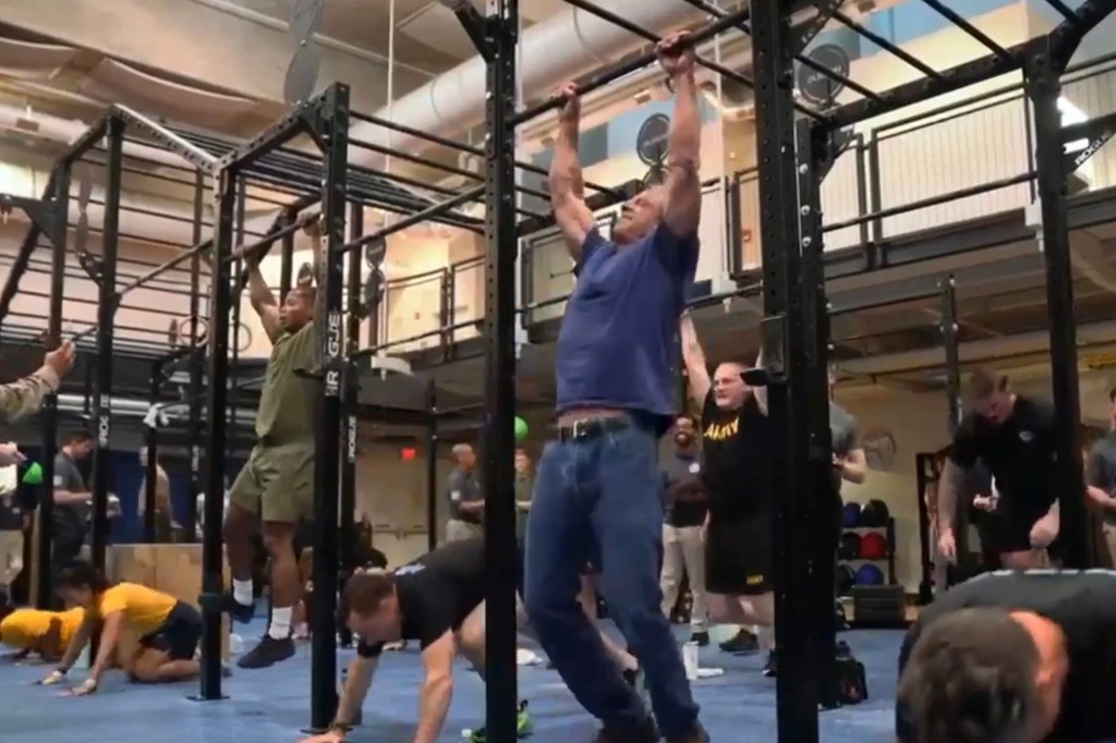 Men performing pull-ups and push-ups in a gym.