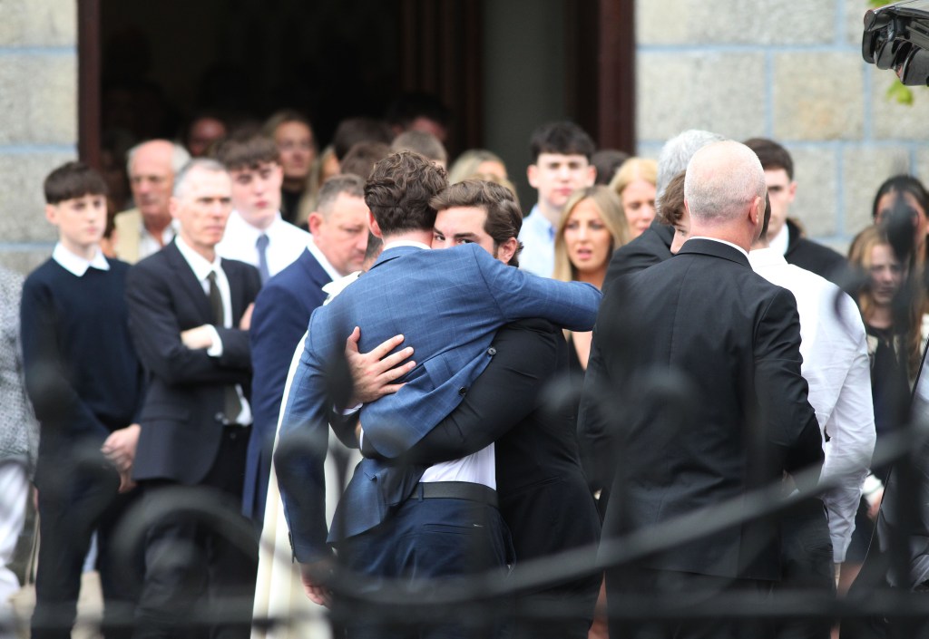 Mourners hugging at Martha Nolan's funeral.