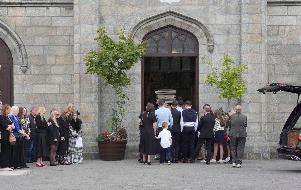 A coffin being carried into a church for a funeral service.