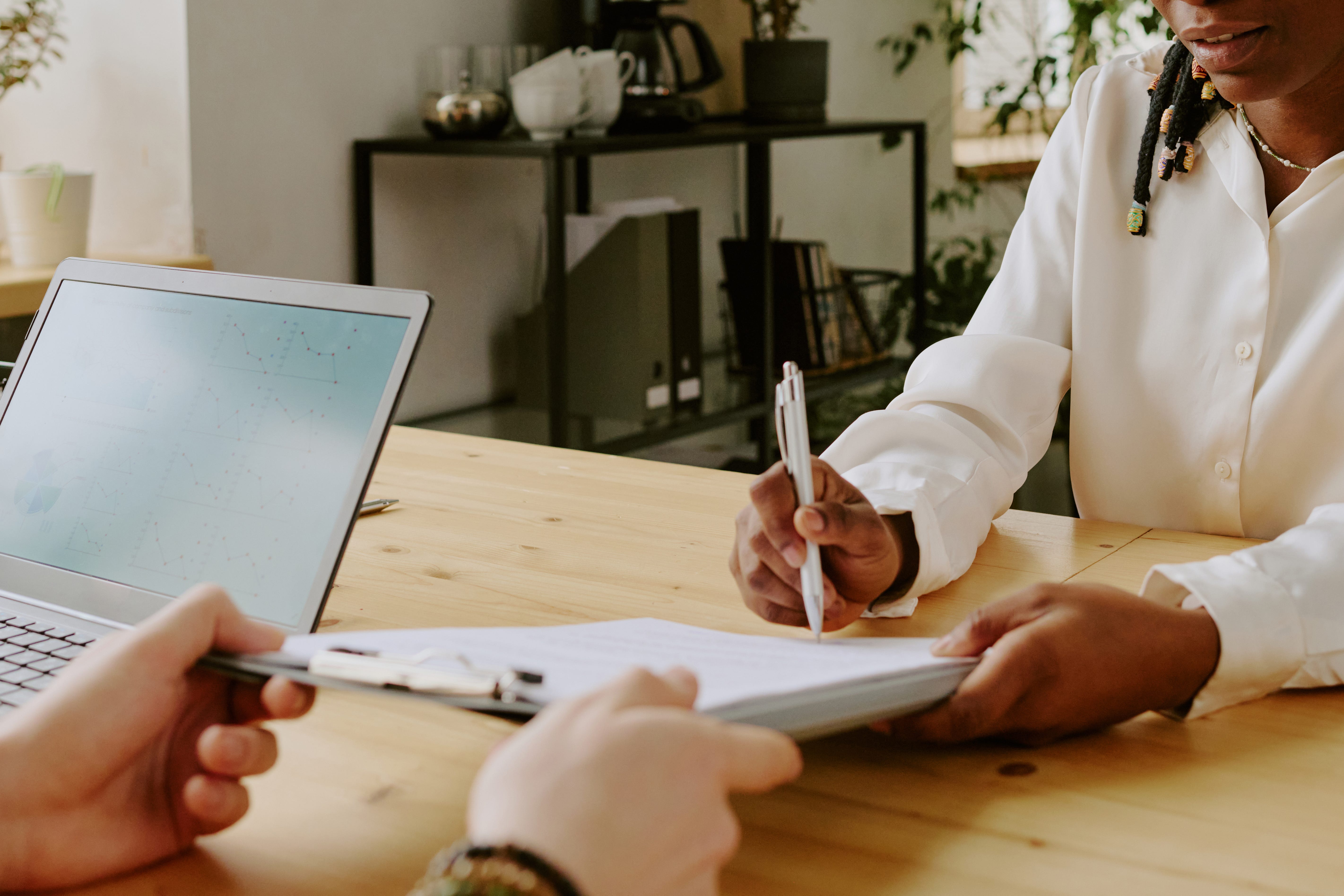 Woman signing papers on clipboard