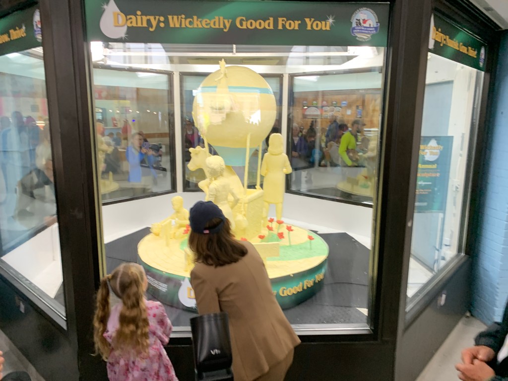 Hochul examining a butter sculpture at the fair.