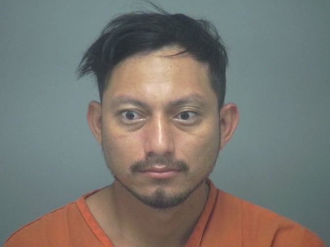 Mugshot of a man in an orange jumpsuit.