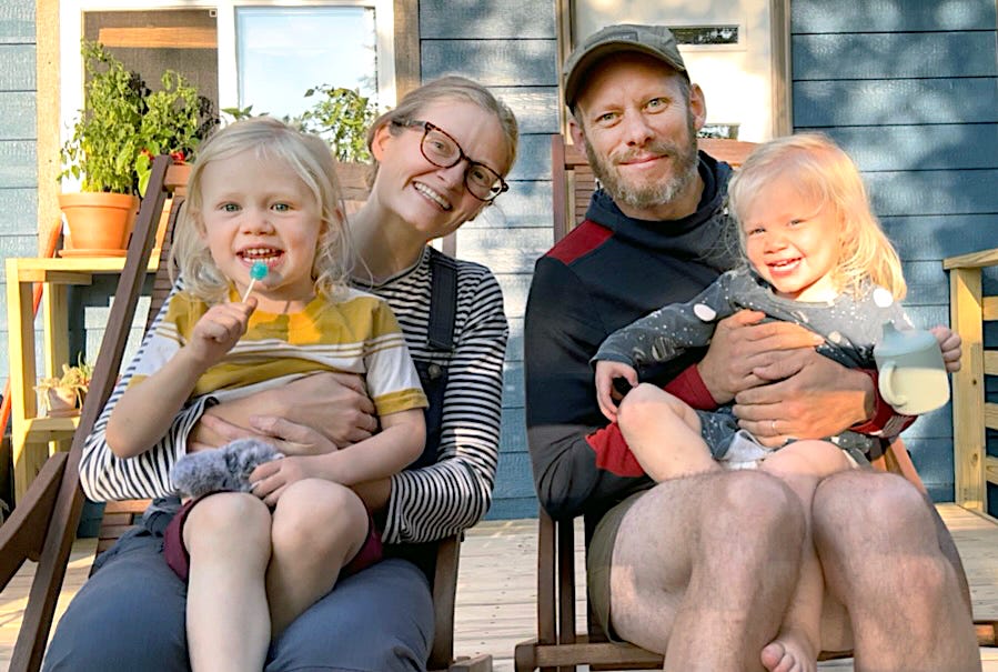 Husband and wife with their two blonde children.