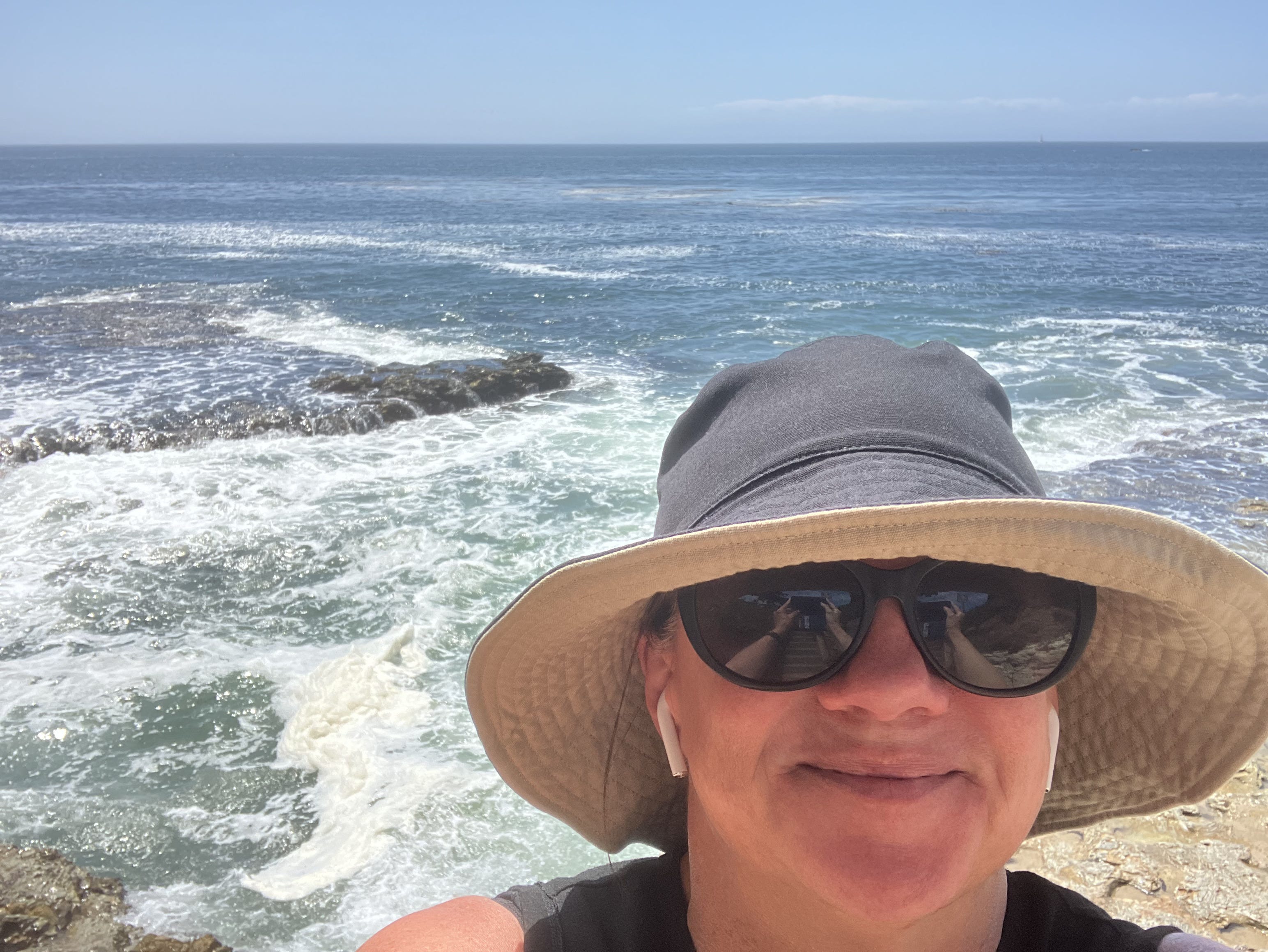 woman in sun hat on the beach with water in background