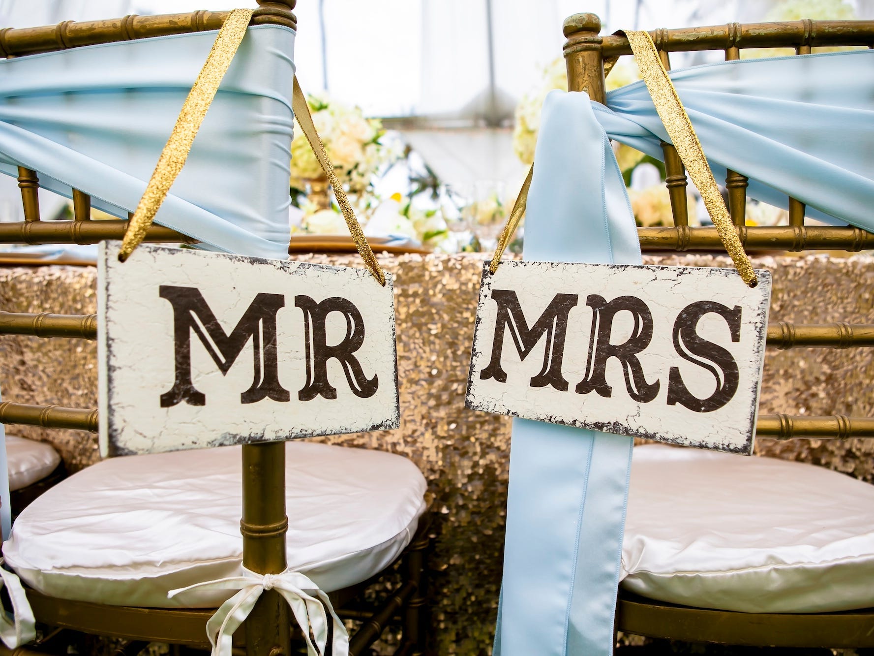 Two wedding chairs with "Mr" and "Mrs" signs on them.