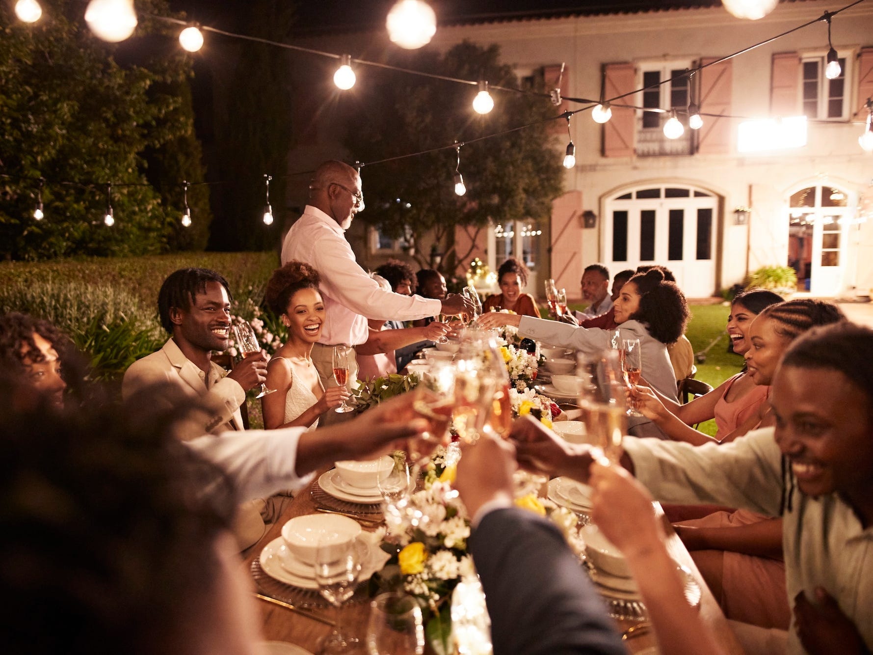 A dinner at a wedding reception. People toast drinks.