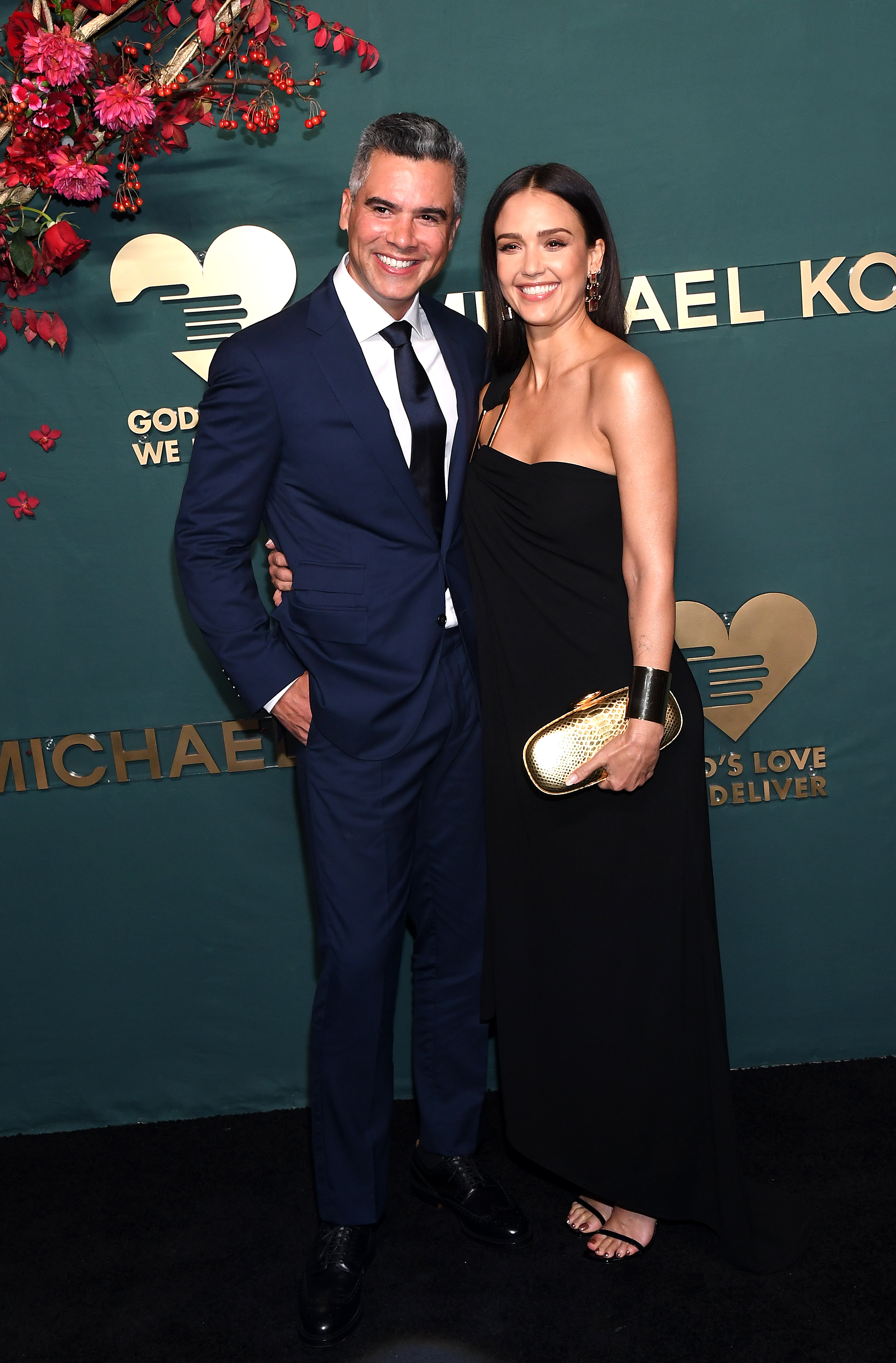 Jessica Alba and Cash Warren pose on a red carpet. 
