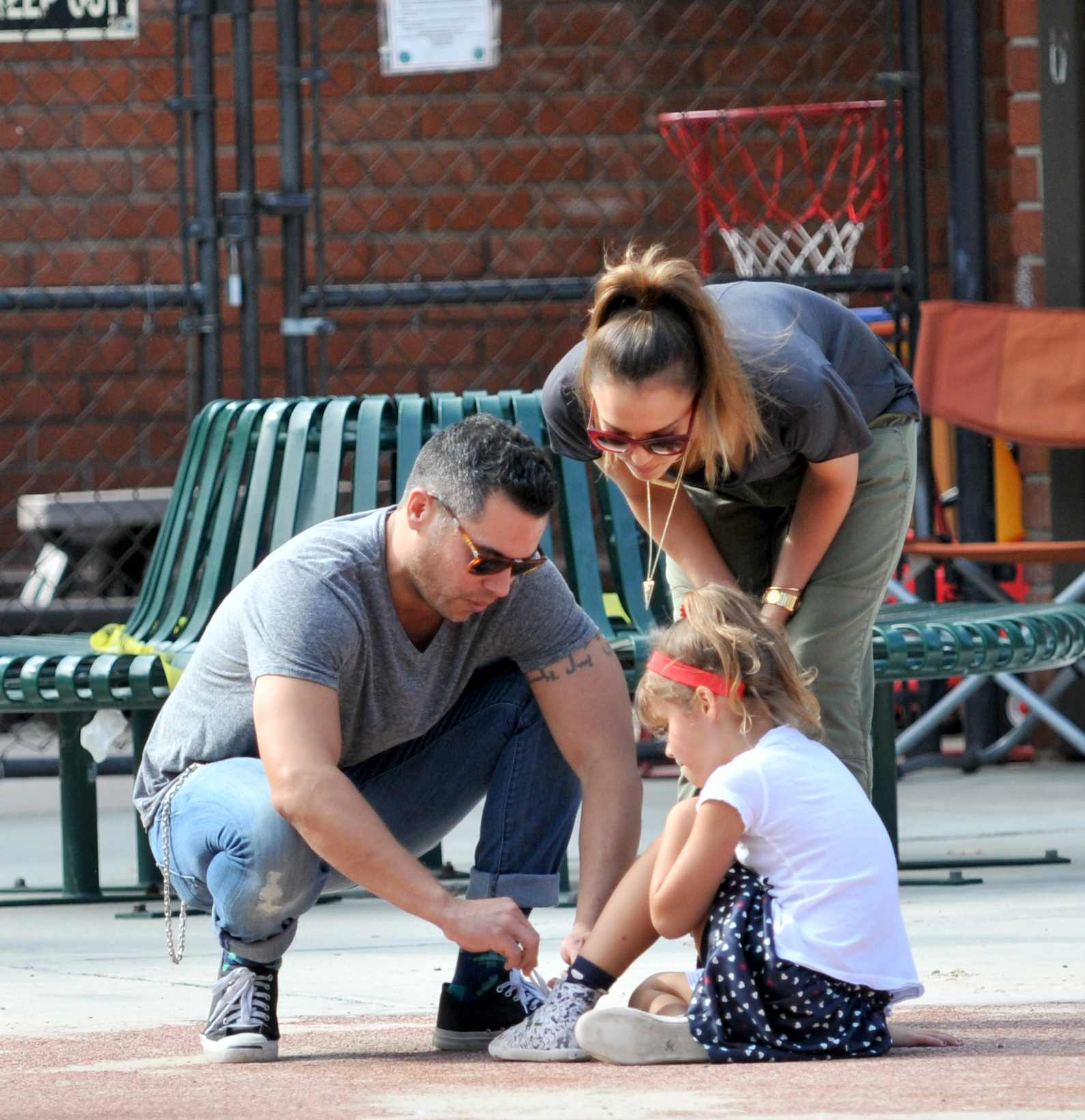 Jessica Alba, Cash Warren, and their daughter tying a shoe. 