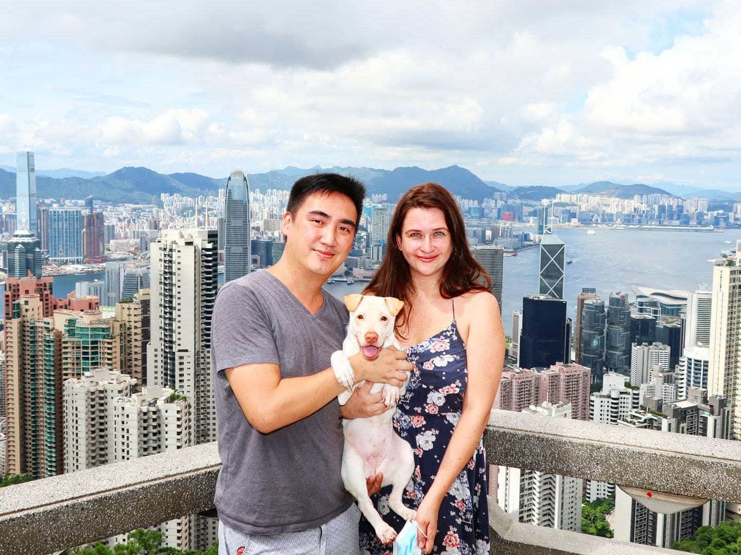 Garron Chiu with his wife and dog, with Hong Kong in the background.