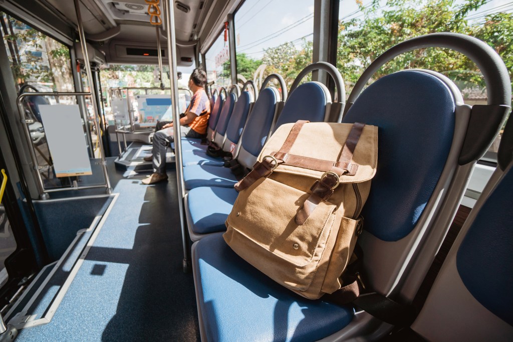 A tan backpack left on a bus seat.