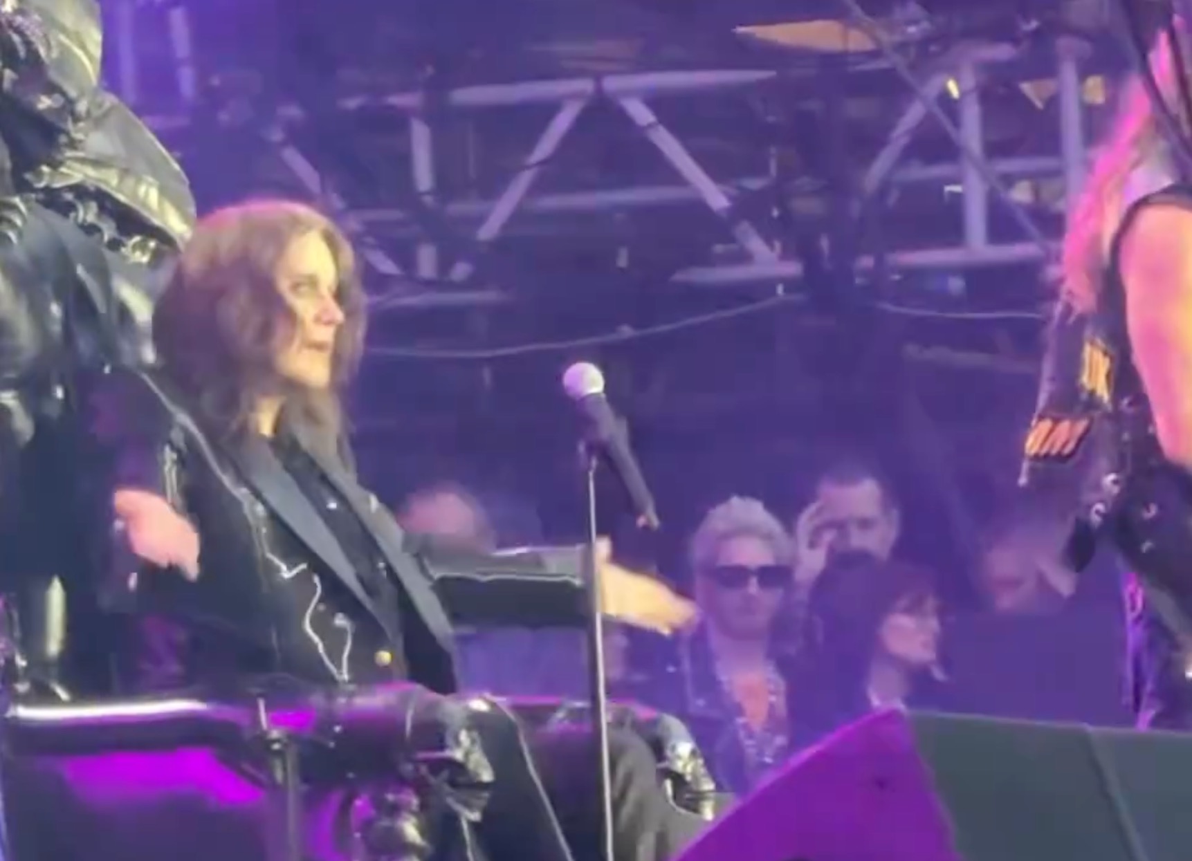 Ozzy Osbourne onstage with purple lights. 