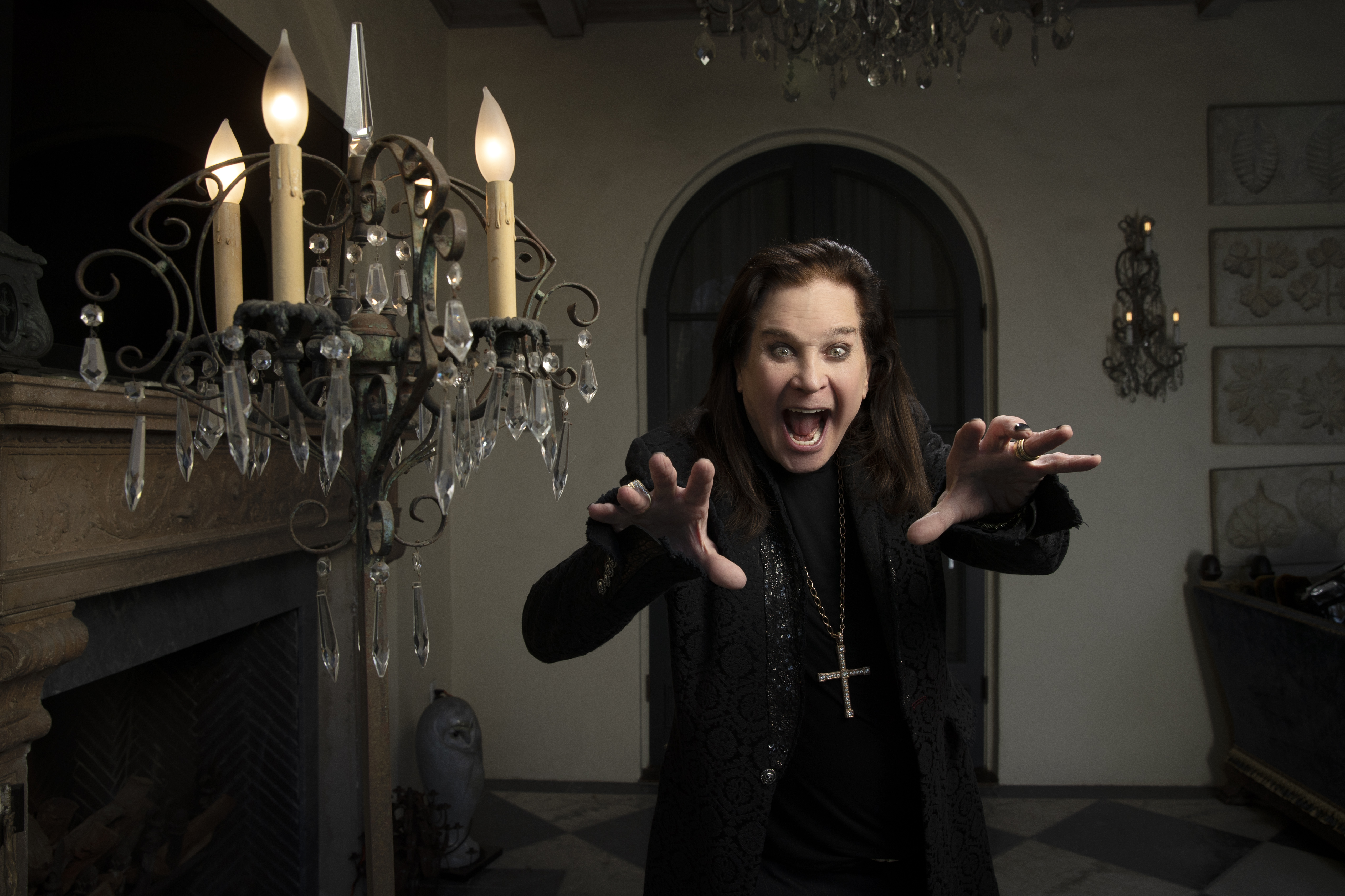 Ozzy Osbourne poses in a dark house. 