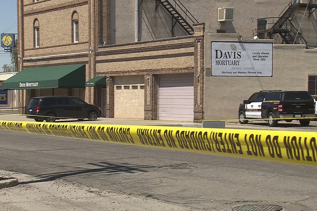 Davis Mortuary in Pueblo, Colorado, with police tape and a police vehicle.