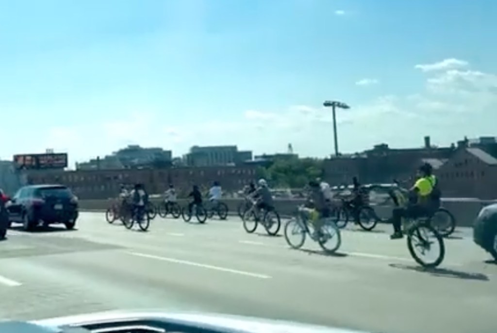 Dozens of cyclists riding on a highway.