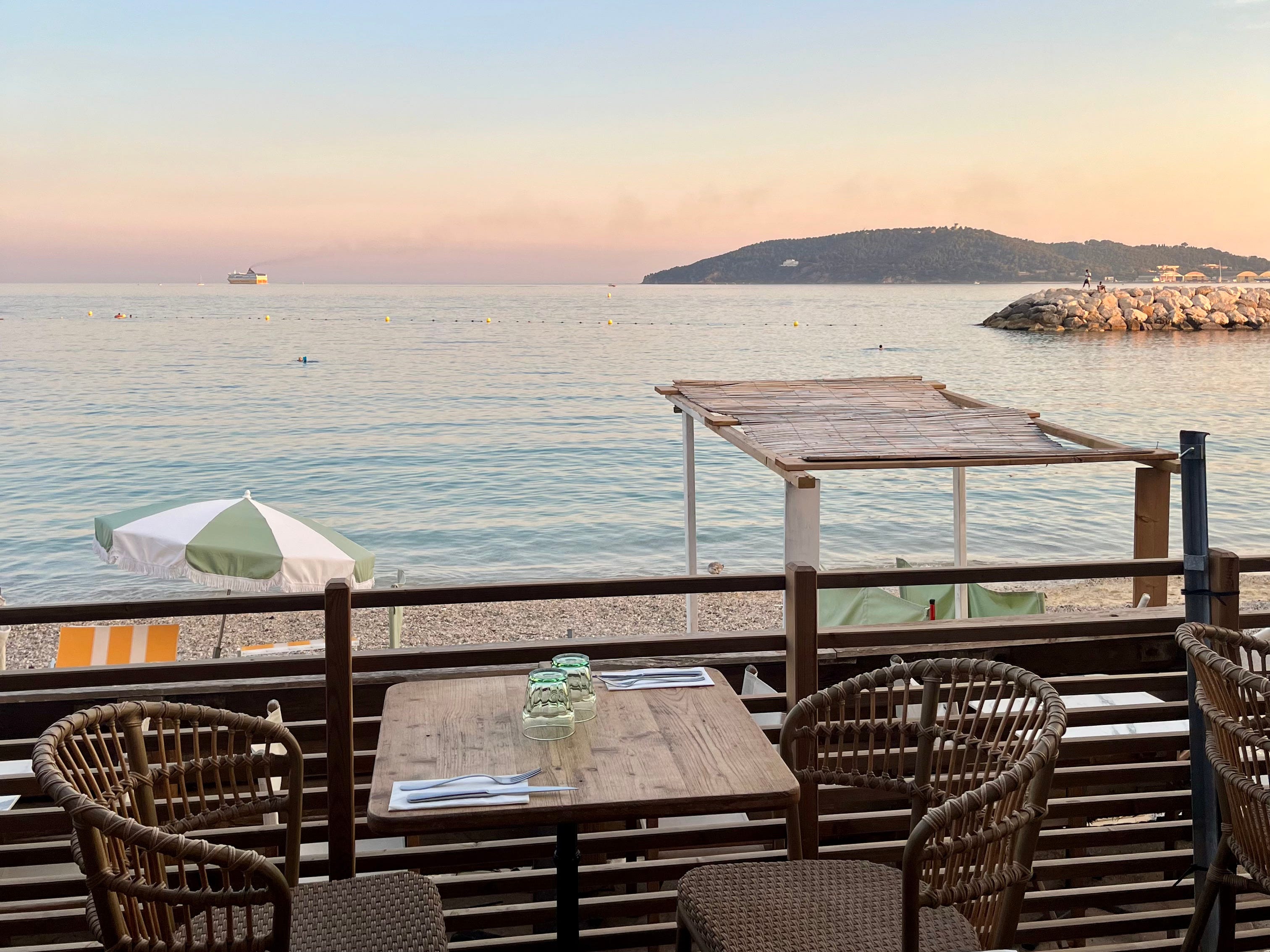 restaurant dinner setting by the sea at sunset