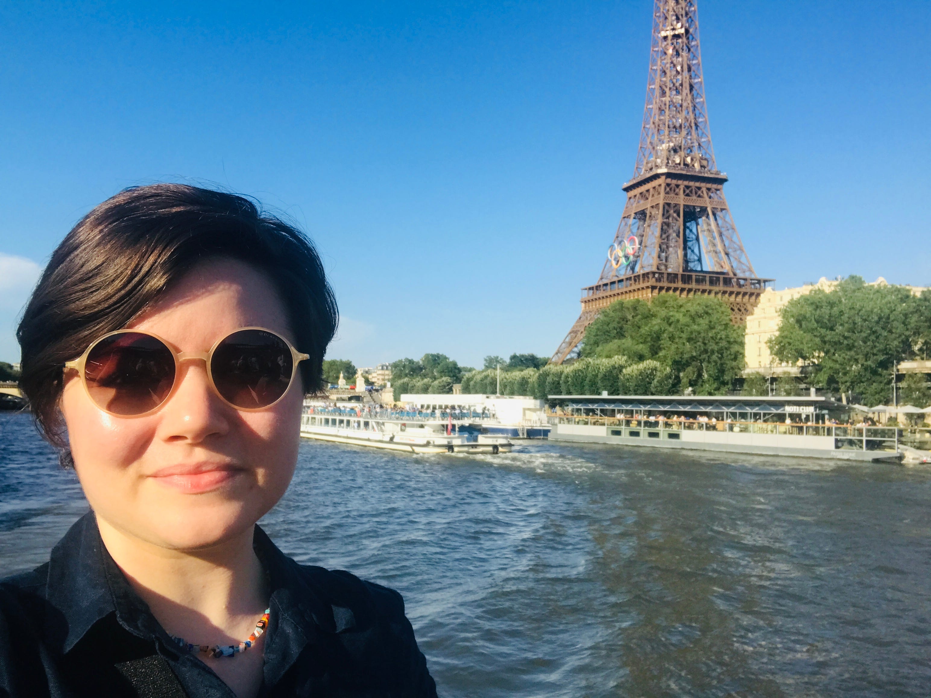moriah posing with the Eiffel tower behind her from a boat in the seine