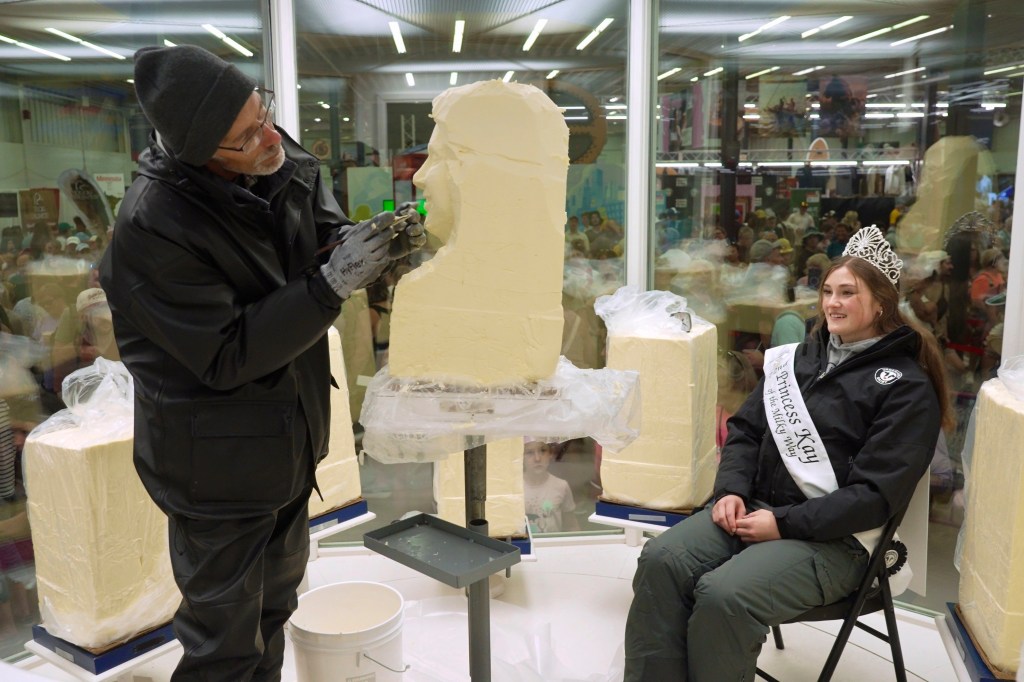 A sculptor carves a butter sculpture of the Princess Kay of the Milky Way.