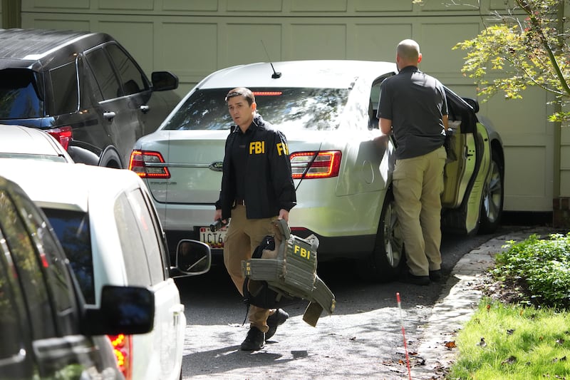 FBI agents work outside the home of John Bolton, former national security adviser to President Trump, August 22, 2025 in Bethesda, Maryland. The FBI conducted an early morning court-authorized search of Bolton's home.