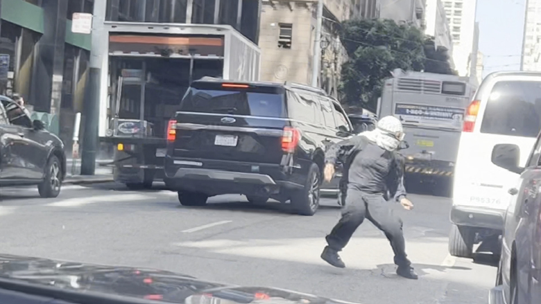 A person running in a San Francisco street during a mob assault on ICE.