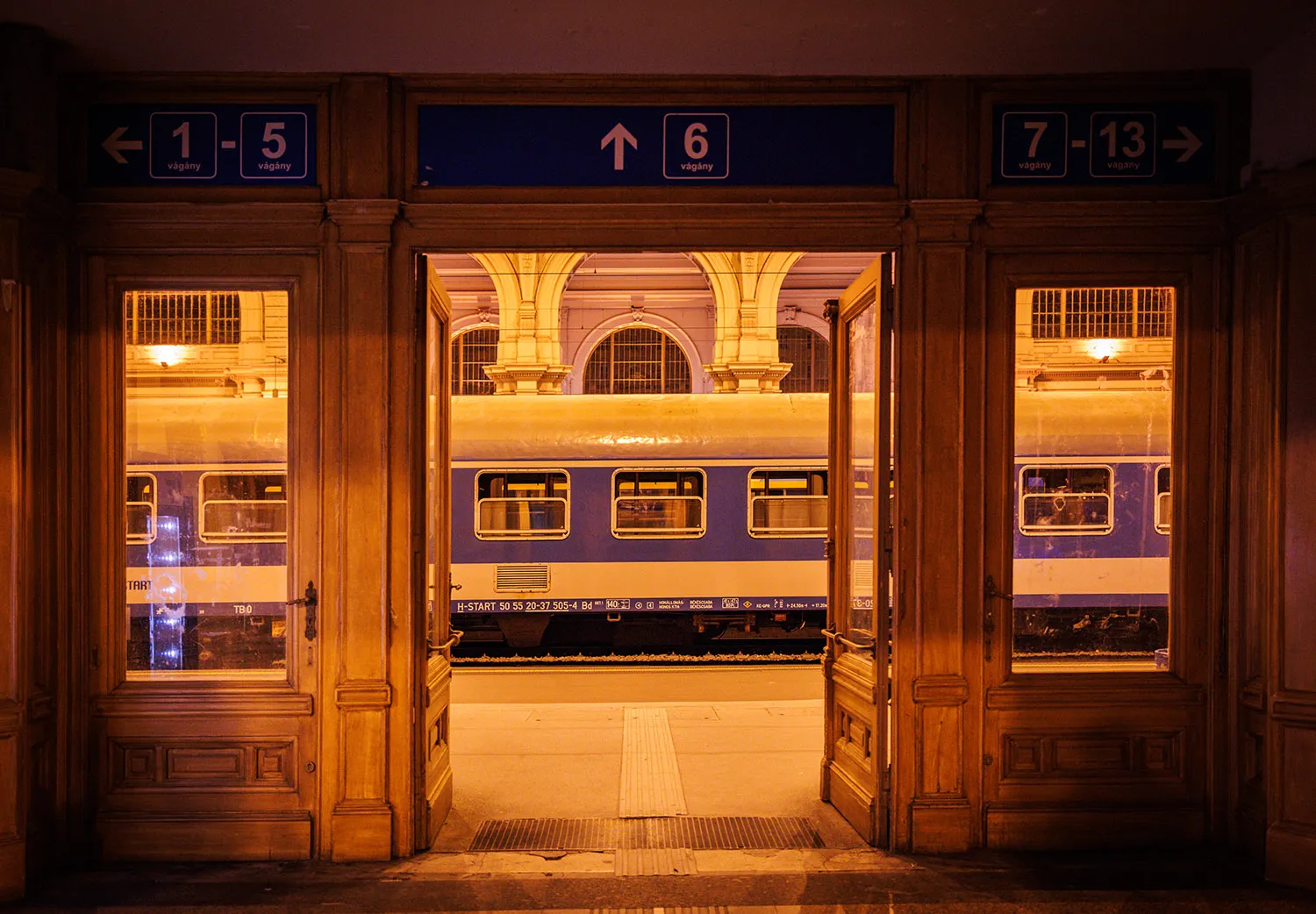 A train on a platform seen through an open doorway.