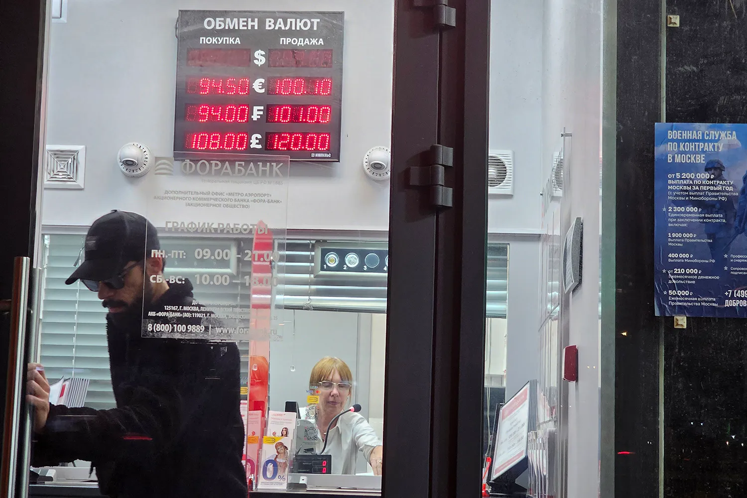 A man opens the door of a currency exchange office.