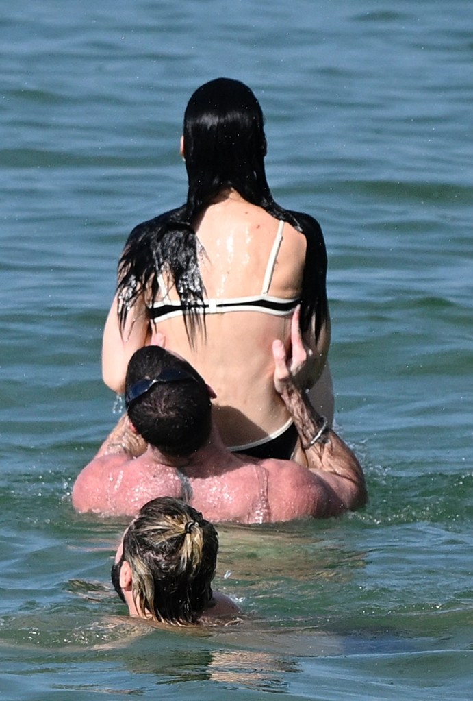 Katy Perry getting picked up by a male friend in the ocean