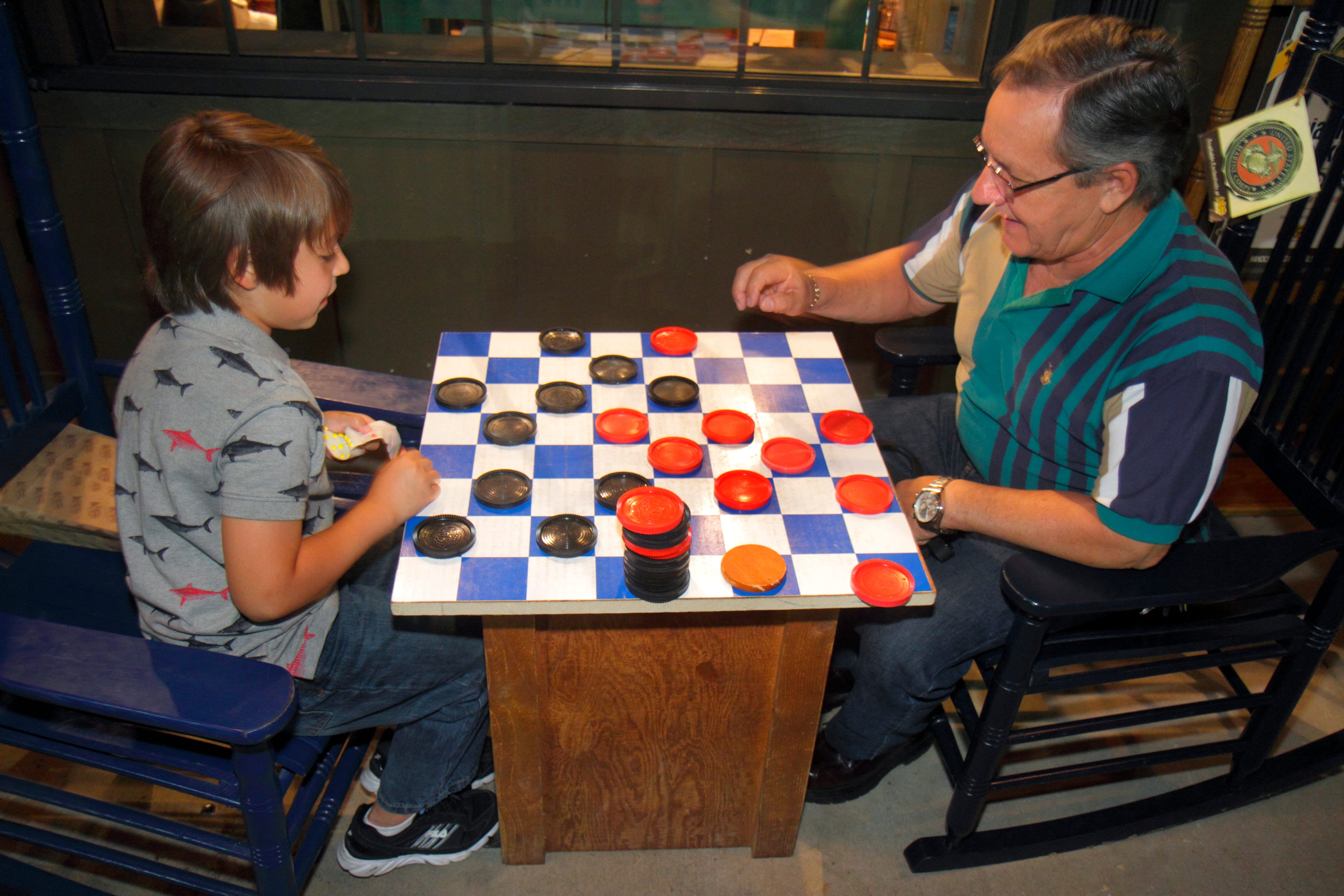 A grandfather and grandson are pictured playing checkers at Cracker Barrel