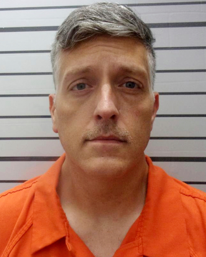 Mugshot of a man in an orange jumpsuit.