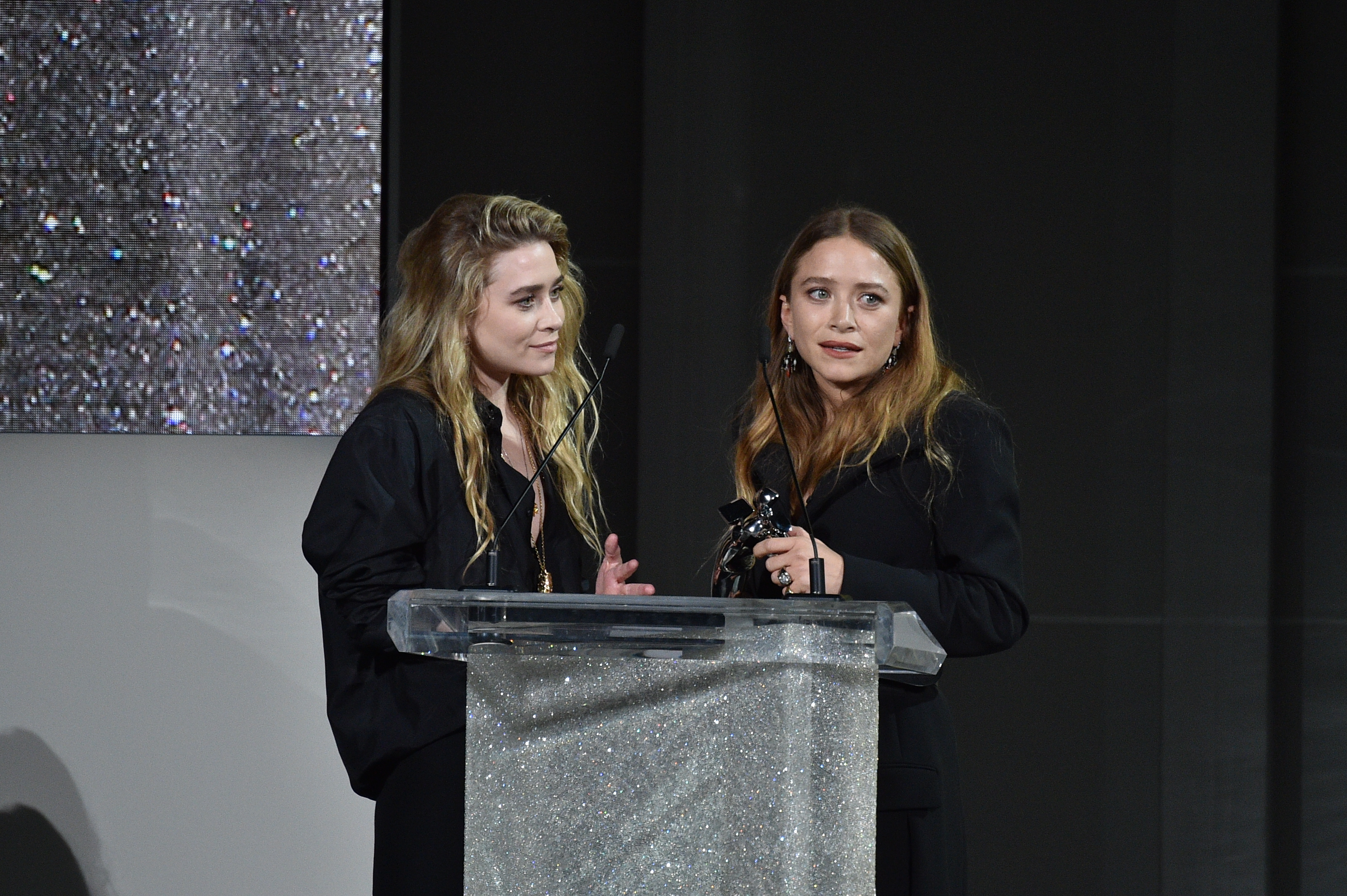 Mary Kate and Ashley Olsen at a podium. 