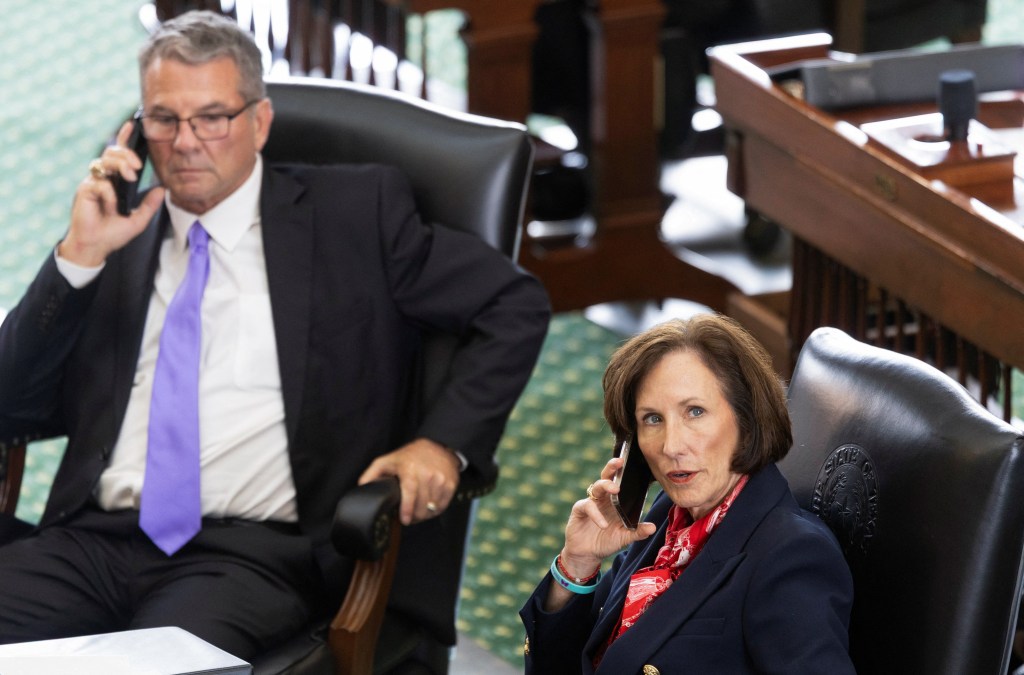 Texas Republican state Senators Charles Perry and Lois Kolkhorst take phone calls on the chamber floor during the bill voting.